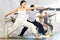 Young girl with multinational group of active people doing stretching exercises during yoga class