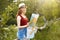 Young girl on nature with hat and map. Summer