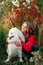 Young girl in a nature park hugging a white dog Samoyed Laika at sunset