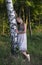 Young girl near the birch in a beautiful dress