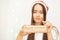 A young girl in a new year`s hat opens a Christmas gift in craft paper