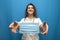 Young girl nurse gives a viral mask on a blue background, the doctor shows a mask from coronavirus