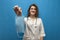 Young girl nurse gives a viral mask on a blue background, the doctor shows a mask from coronavirus