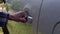 A young girl opens the gas tank cover in her car. Close up of a young girl`s hand open the gas tank door in her car.