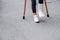 Young girl in orthopedic cast on crutches walking on the street near the road. Child with a broken leg on crutches