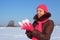 Young girl outdoor in winter holds snow