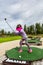 Young girl outdoors at a driving range playing golf and practice her swing.