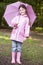 Young girl outdoors with umbrella smiling