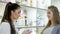 Young girl pharmacist advises pregnant customer. Pharmaceutical store concept