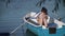 Young girl with a phone sits in a boat