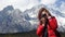 Young girl photographer she force on other, with snow mountain Jade Dragon background in Lijiang, in winter