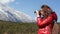 Young girl photographer  she force on other, with snow mountain Jade Dragon background in Lijiang,  in winter