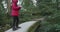 young girl photographing a stream from a concrete bridge in a Japanese park then walks off the bridge