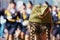 A young girl with pigtails at the military parade on Victory Day. Close view from behind. In the background, a column of