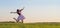 young girl in pink dress jumping in field