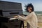 Young girl play on old piano on se beach