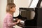 Young girl playing grand piano