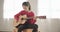 Young girl playing guitar and singing