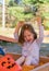 Young girl playing in a sandpit made from corn cob seeds