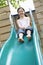 Young Girl Playing On Slide In Park