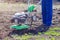 Young girl plows the land with a cultivator in spring garden