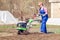 Young girl plows the land with a cultivator in spring garden