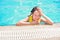 Young girl in the pool. Bright summer photo. The teenager is resting near the pool in summer.Vacation, holidays, family