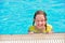 Young girl in the pool. Bright summer photo. The teenager is resting near the pool in summer.Vacation, holidays, family