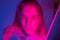 Young girl portrait in neon pink and violet lights with glitter freckles on face. Clubber, night life concept.