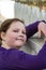 Young girl posing leaning on picket fence