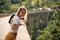 A young girl is posing for a photo while standing on the viaduct. Nature, canyon, landscape