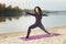 A young girl practices yoga by the river.