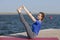 Young girl practices yoga on the shore of the lake, the concept of enjoying privacy and concentration, sunlight