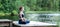 Young  girl  practicing yoga in the nature on the lake. Female happiness. Landscape background,  Panoramic view
