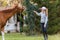 Young girl preparing horse for ride