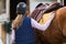 Young girl preparing horse for ride