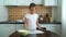 Young girl preparing working surface for dough kneading spreading flour on dark table in kitchen