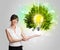 Young girl presenting idea light bulb with green tree