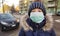 Young girl in protective sterile medical mask on her face looking at camera outdoors,  virus, Chinese pandemic coronavirus concept