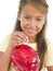 Young girl putting coin into piggy bank