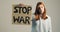 Young girl raises up the billboard that says stop war during the protest