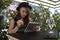 Young girl reading on iPad in a caffe enjoying summer