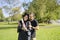 Young girl recently graduated, dressed in cap and gown, with her degree in her hands, celebrating with her family on the universit