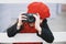 a young girl in a red beret and scarf takes pictures on the city street
