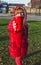 Young girl in red clothes holding red plastic cup forward-healthy lifestyle concept - Image