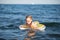 young girl in red glasses and a green bathing suit resting on the sea. childhood and sea air