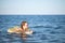 young girl in red glasses and a green bathing suit resting on the sea. childhood and sea air