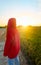 Young girl with red jacket from behind in a rice field at sunset time. Concept tranquility, nature, chromatic contrast