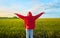 Young girl in red jacket raising her arms in a rice field at sunset. Concept happiness, euphoria, nature, chromatic contrast