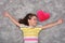 Young girl with red plush heart lying on the carpet